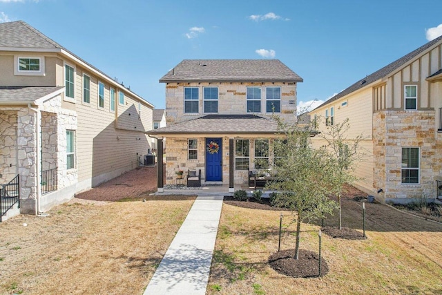 view of front of house with cooling unit, stone siding, a porch, and a front yard