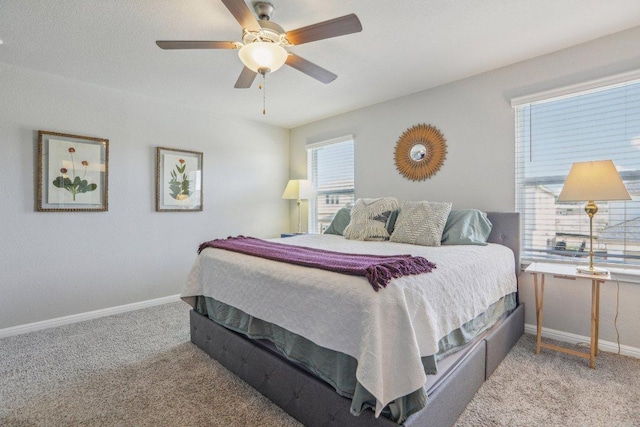 carpeted bedroom with a ceiling fan and baseboards