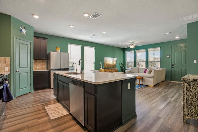 kitchen with visible vents, light countertops, appliances with stainless steel finishes, wood finished floors, and a sink