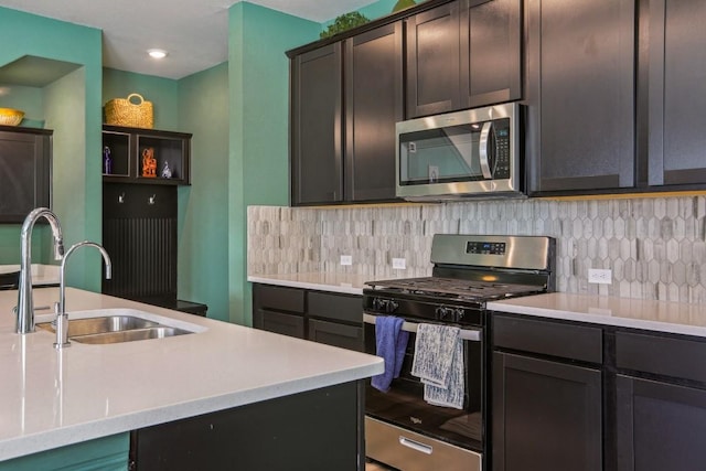 kitchen with backsplash, stainless steel appliances, light countertops, and a sink