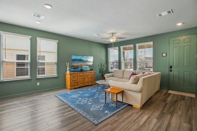 living room with ceiling fan, visible vents, wood finished floors, and recessed lighting