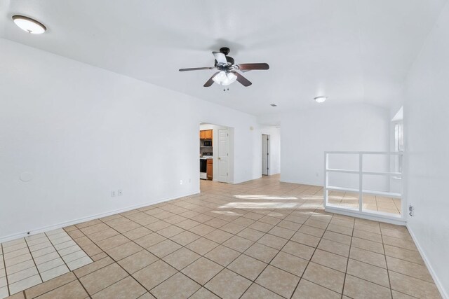 spare room featuring ceiling fan, baseboards, and light tile patterned floors