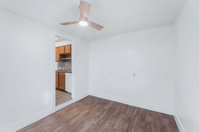 unfurnished room featuring crown molding, baseboards, a ceiling fan, and light wood-style floors