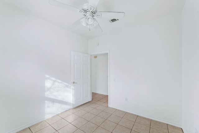 spare room with baseboards, light tile patterned flooring, visible vents, and a ceiling fan