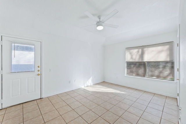 empty room with light tile patterned floors, baseboards, and a ceiling fan