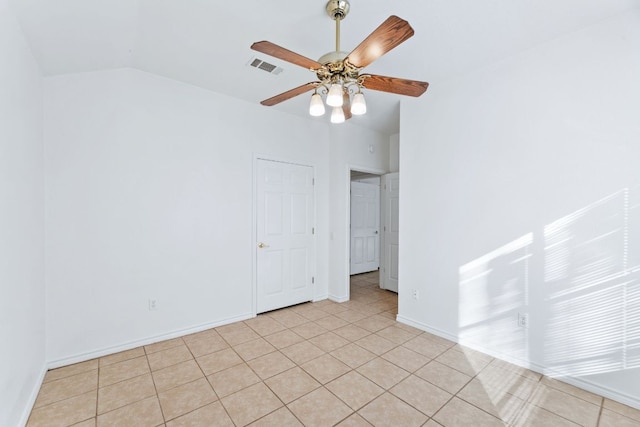 unfurnished room featuring light tile patterned flooring, a ceiling fan, visible vents, vaulted ceiling, and baseboards