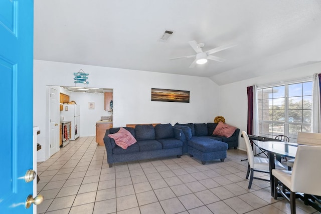 living room with light tile patterned floors, ceiling fan, visible vents, and vaulted ceiling