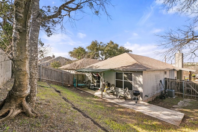 back of house with a patio, a chimney, a shingled roof, central AC unit, and a fenced backyard