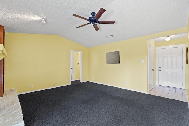 carpeted empty room featuring visible vents, a ceiling fan, vaulted ceiling, a textured ceiling, and baseboards