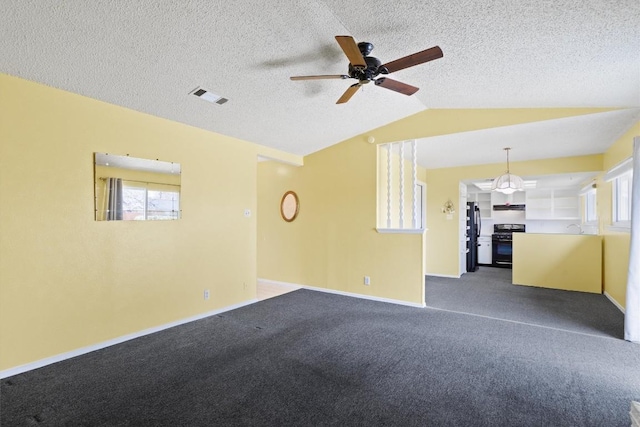 spare room with plenty of natural light, visible vents, vaulted ceiling, and carpet flooring