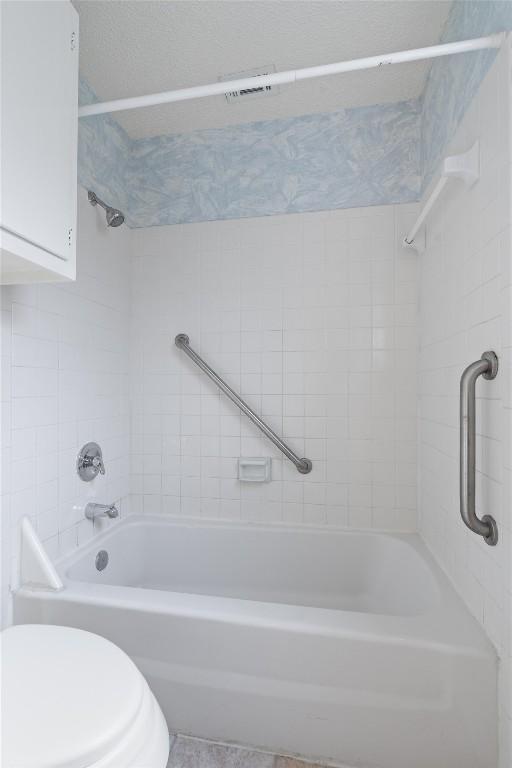 bathroom featuring tub / shower combination and toilet