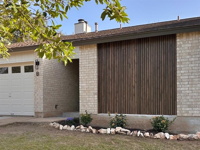 view of property exterior with brick siding, a chimney, and an attached garage