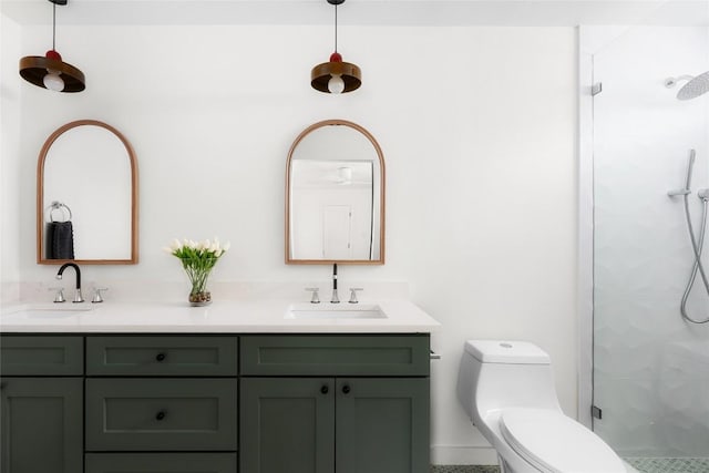 full bath with a sink, tiled shower, toilet, and double vanity