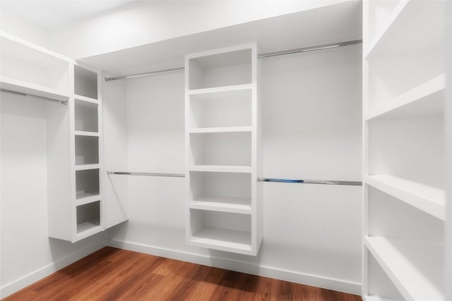 walk in closet with wood finished floors