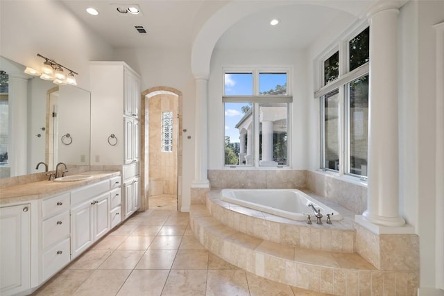 bathroom featuring a bath, vanity, and decorative columns