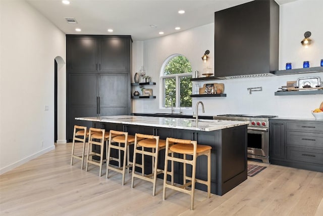 kitchen with visible vents, arched walkways, extractor fan, open shelves, and luxury stove