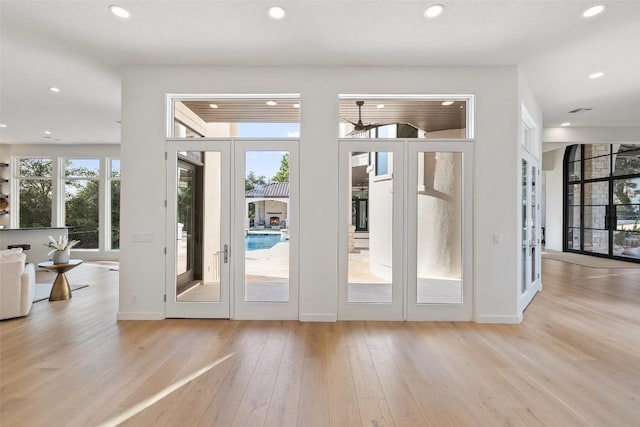 entryway with a healthy amount of sunlight, recessed lighting, wood finished floors, and french doors