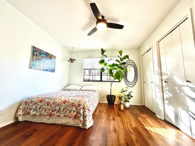 bedroom with multiple closets, a ceiling fan, and wood finished floors