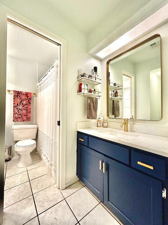 full bath with visible vents, vanity, toilet, and tile patterned floors