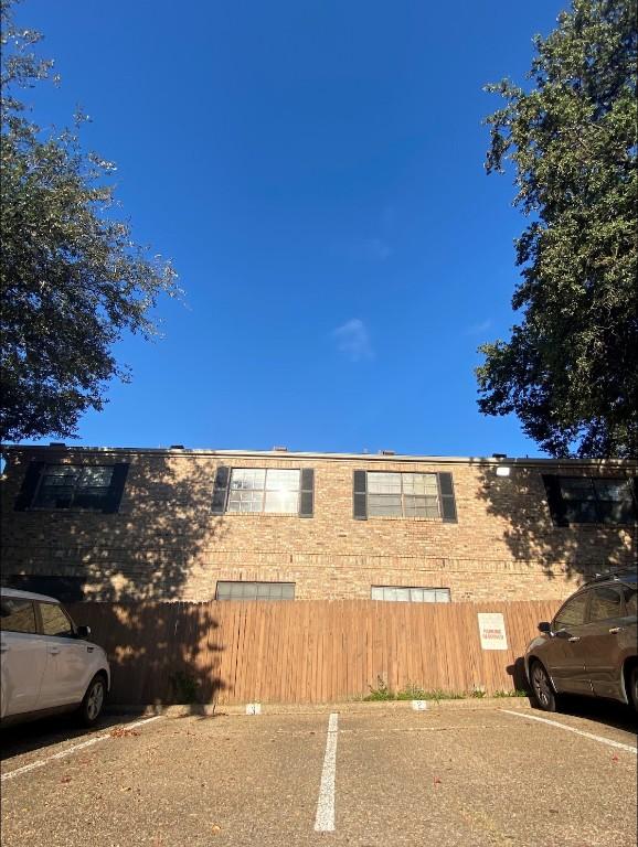 view of home's exterior featuring uncovered parking and fence