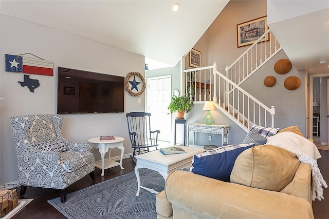 living area with high vaulted ceiling, stairs, baseboards, and wood finished floors