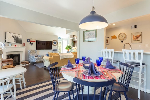 dining space with a fireplace and wood finished floors