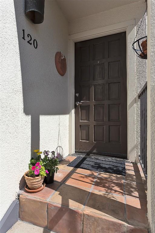 property entrance featuring a garage and stucco siding