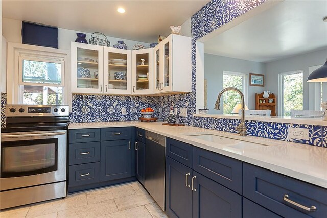 kitchen with a sink, decorative backsplash, appliances with stainless steel finishes, and light countertops