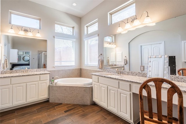 bathroom with a shower stall, a sink, a garden tub, and wood tiled floor