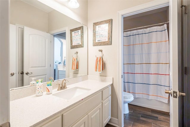 full bathroom with toilet, wood finished floors, vanity, baseboards, and shower / bath combination with curtain