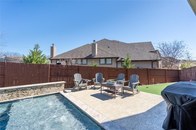 view of swimming pool with a patio area, a fenced backyard, and a grill