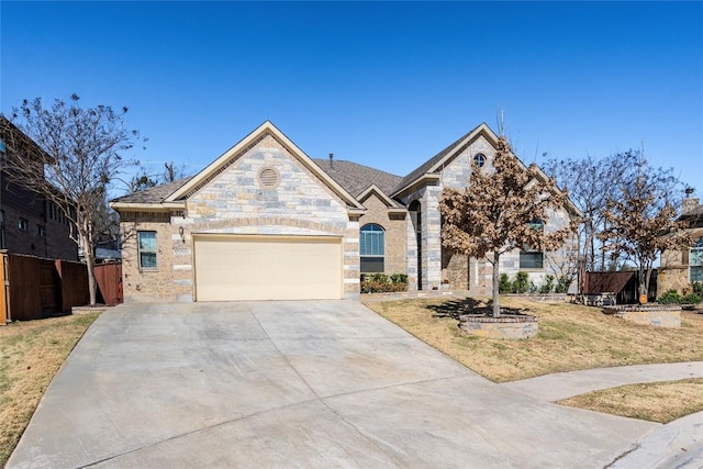 french country style house featuring fence, a garage, stone siding, driveway, and a front lawn