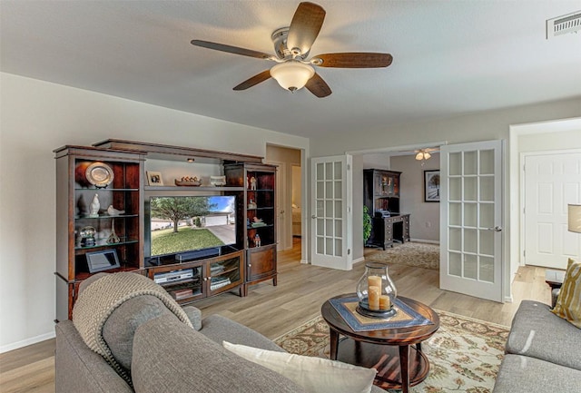 living room featuring baseboards, visible vents, wood finished floors, and french doors