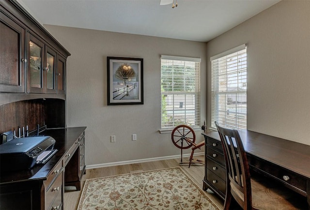 home office with light wood-type flooring and baseboards