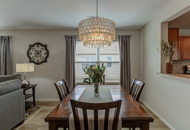 dining room featuring baseboards and light wood finished floors