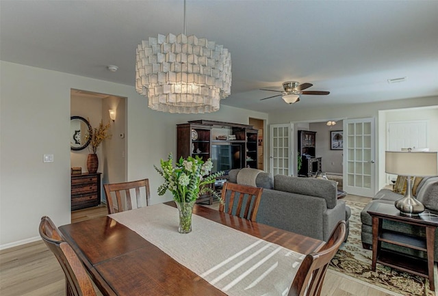 dining area featuring light wood-style floors, french doors, baseboards, and a ceiling fan