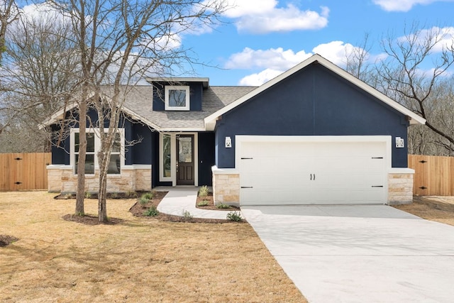 view of front of house with stone siding, fence, an attached garage, and a gate