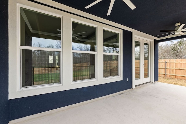 exterior space featuring a ceiling fan, french doors, fence, and stucco siding