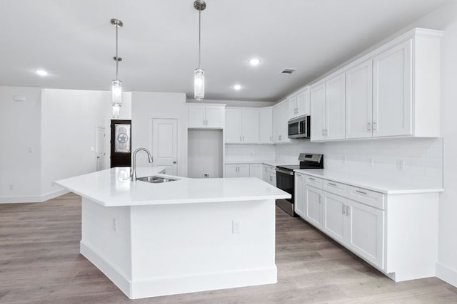 kitchen featuring appliances with stainless steel finishes, a sink, and light wood-style flooring