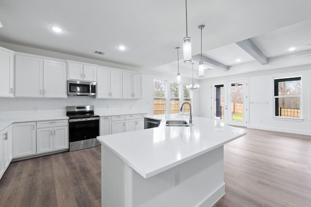 kitchen featuring stainless steel appliances, visible vents, a sink, and decorative backsplash