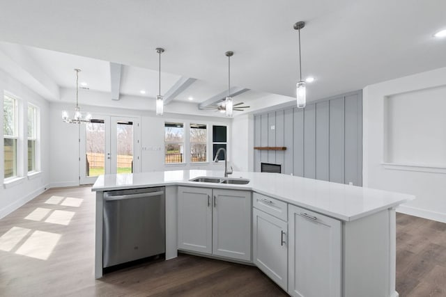 kitchen featuring a healthy amount of sunlight, dishwasher, a sink, and wood finished floors