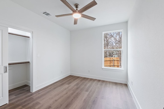 unfurnished bedroom featuring a closet, visible vents, light wood-style flooring, and baseboards