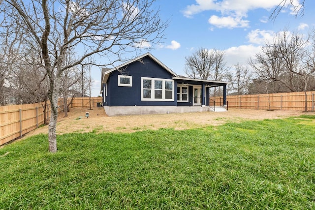 back of property with a lawn and a fenced backyard