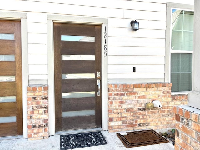 doorway to property with brick siding