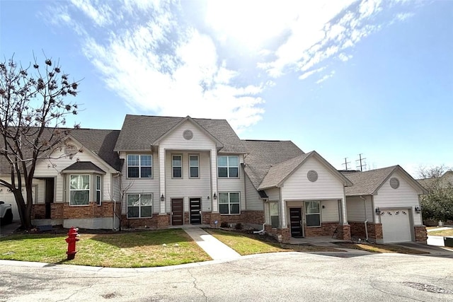 view of front facade with a garage, a front yard, and brick siding