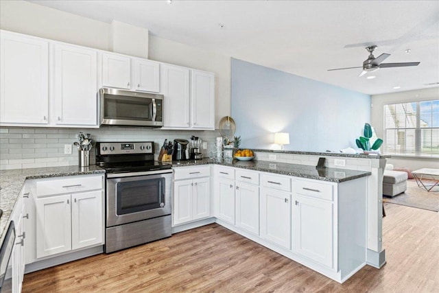 12185 Chelsea Glen Place Br, Austin, TX 78753 - kitchen featuring stainless steel appliances, a peninsula, white cabinets, open floor plan, and tasteful backsplash