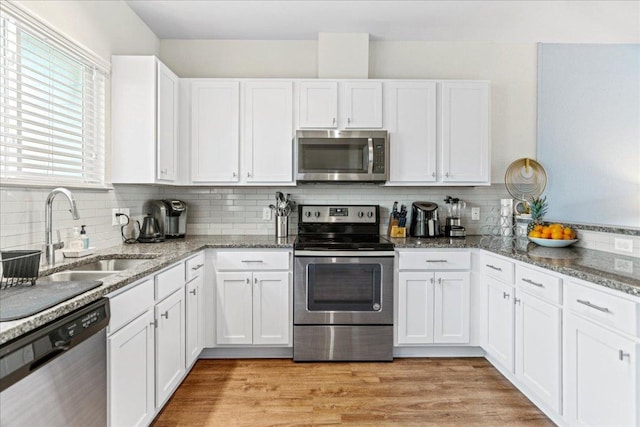 12185 Chelsea Glen Place Br, Austin, TX 78753 - kitchen featuring stainless steel appliances, a sink, white cabinets, and tasteful backsplash