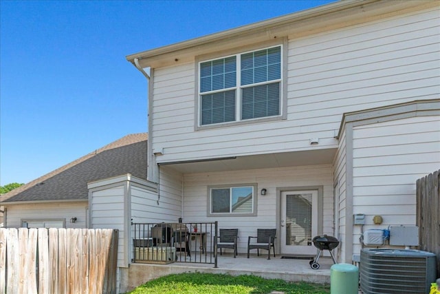 rear view of property with a patio area, central AC, and fence