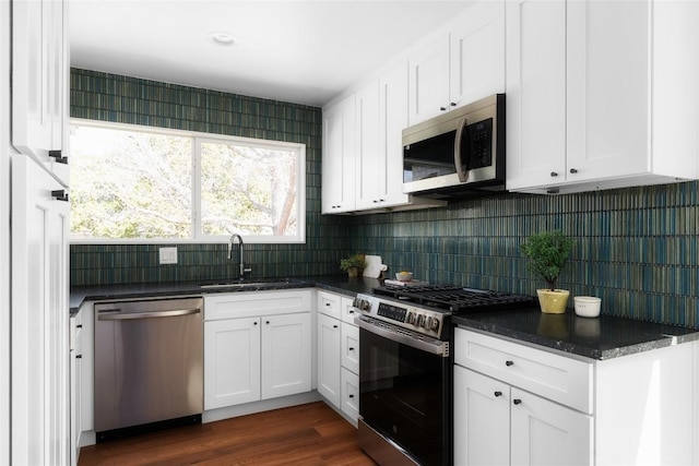 kitchen with a sink, decorative backsplash, appliances with stainless steel finishes, and white cabinetry