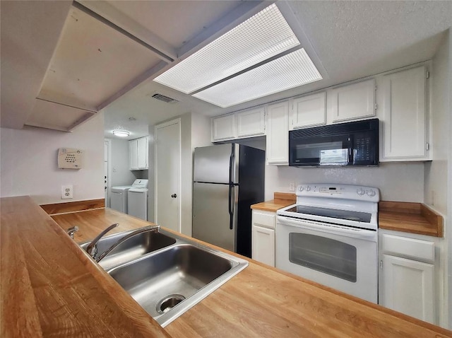 kitchen with white range with electric cooktop, wooden counters, freestanding refrigerator, black microwave, and independent washer and dryer